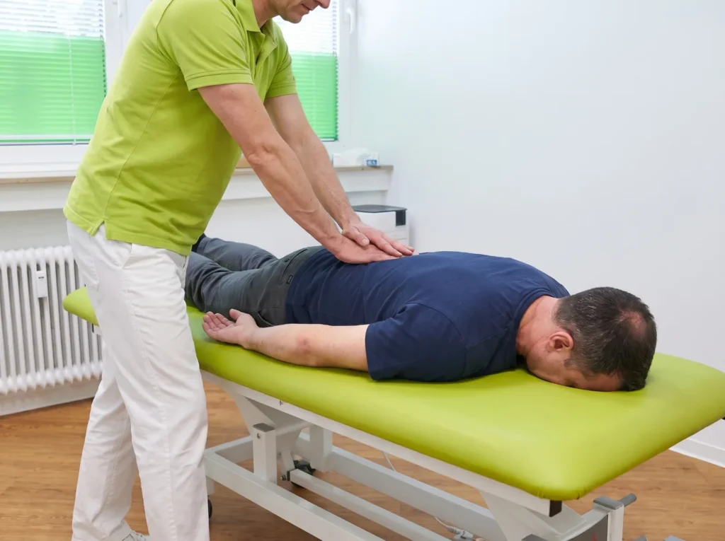 Mobilisation der Lendenwirbelsäule mit beiden Händen in der Manuellen Therapie